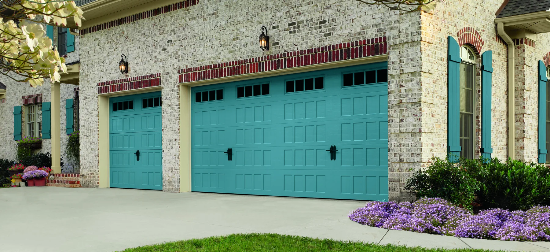 Amarr Designer's Choice garage door in teal Amalfi finish against a brick home exterior