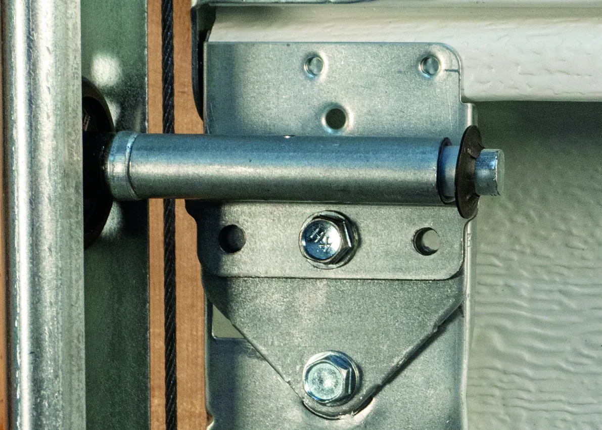 Close-up of Amarr Quiet Door nylon roller sleeve isolating metal contact on hinge bracket
