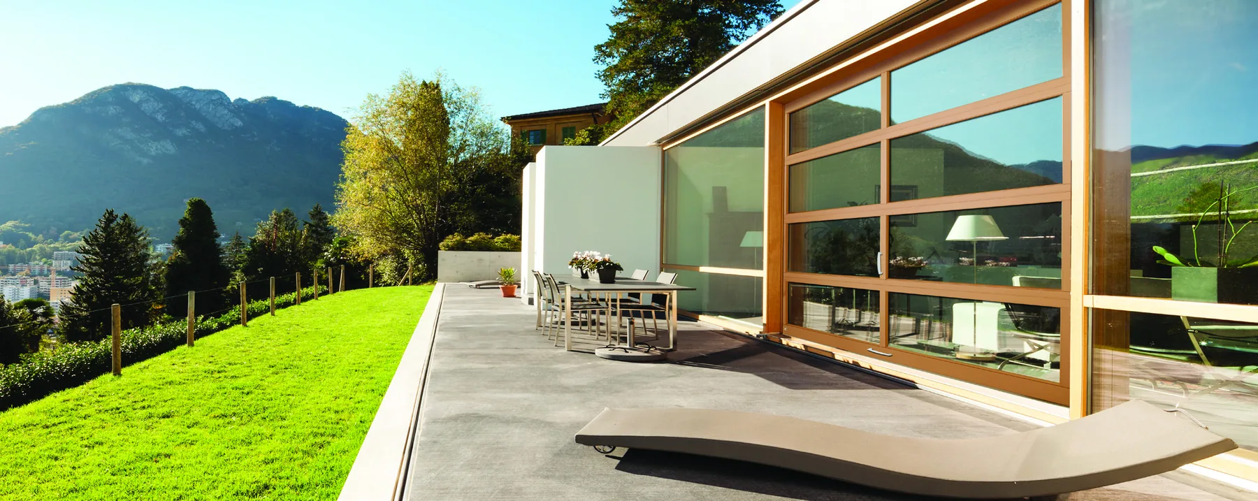 Amarr Vista garage door in copper anodize finish with clear glass panels on a contemporary home