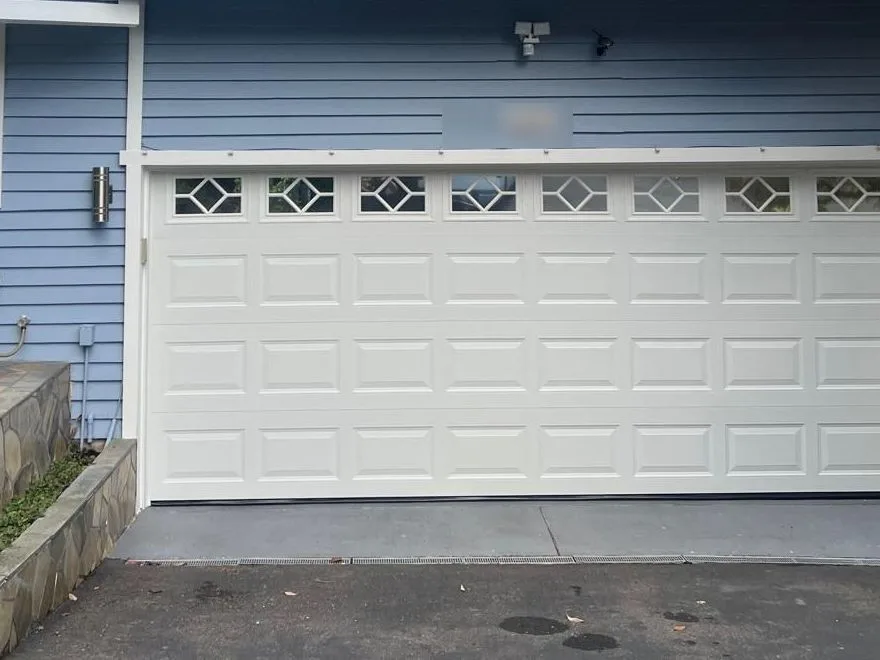 New white garage door with diamond windows on a blue Bellevue home