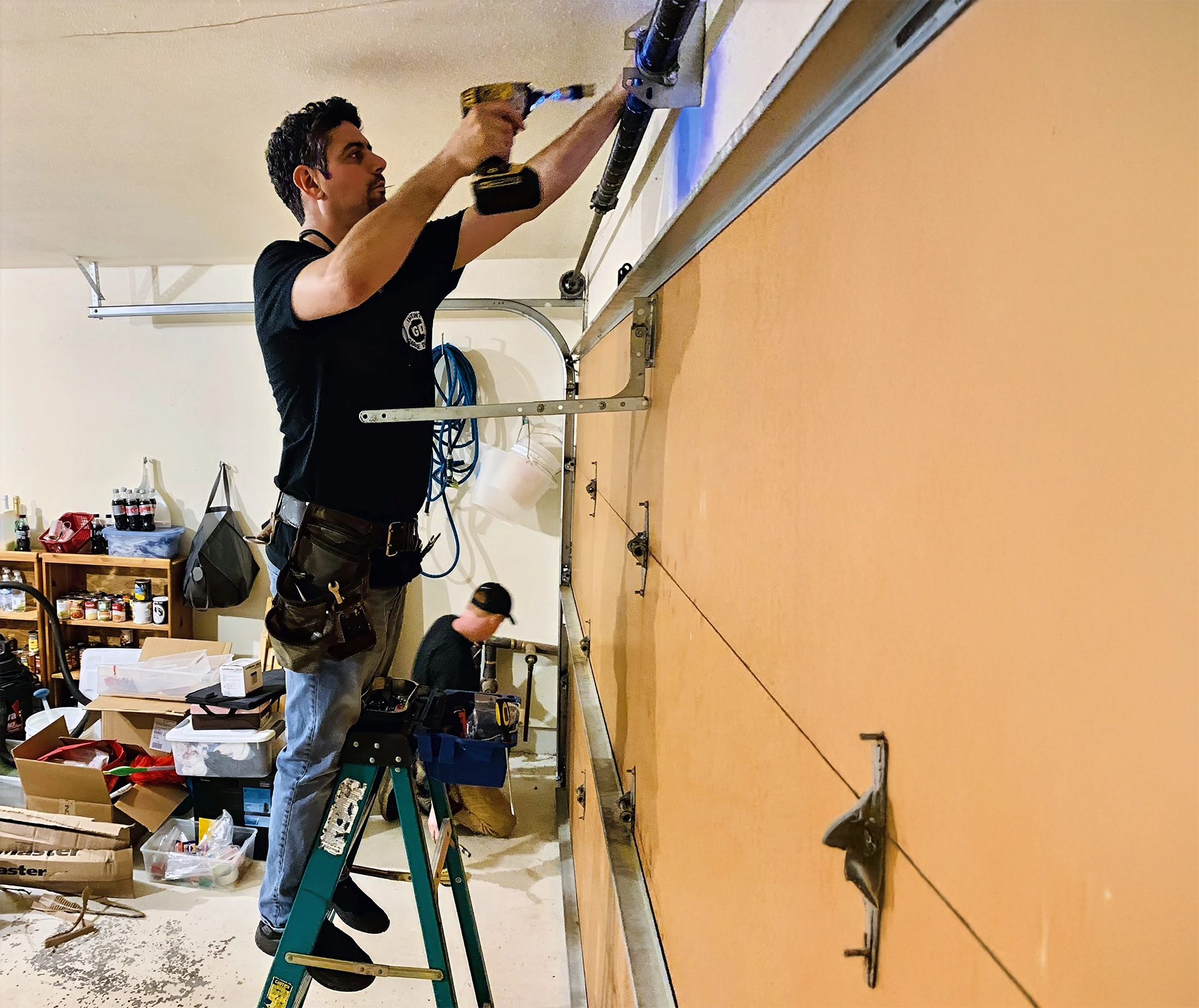 Garage door technician repairing opener mechanism in Renton Washington